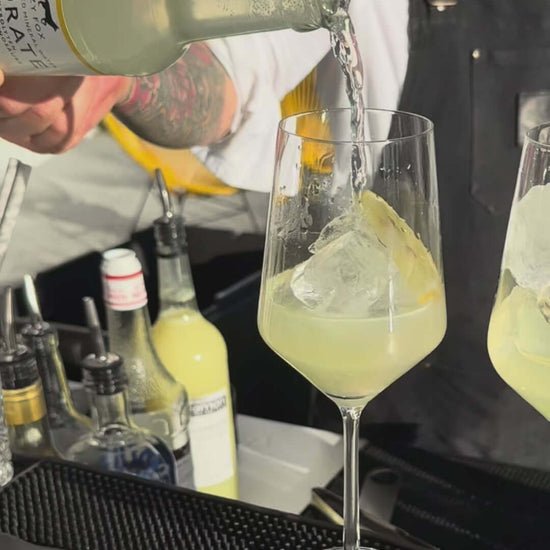 Bartender pouring Fizzy Fox Hydrate Lemon Soda into a glass filled with ice, showcasing a refreshing drink experience.